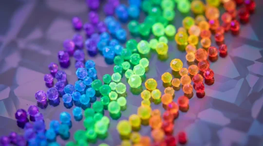 Vision microscopique de nanocristaux de différentes tailles émettant une lumière multicolore sur un panneau solaire semi-transparent